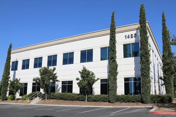 Exterior of a white, two-story building with parking lot