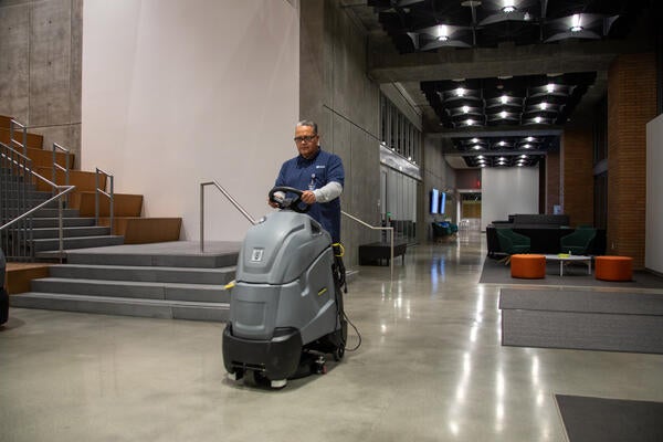 Custodial riding cleaning equipment in lobby