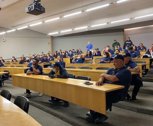 Custodians sitting in chairs in a lecture hall