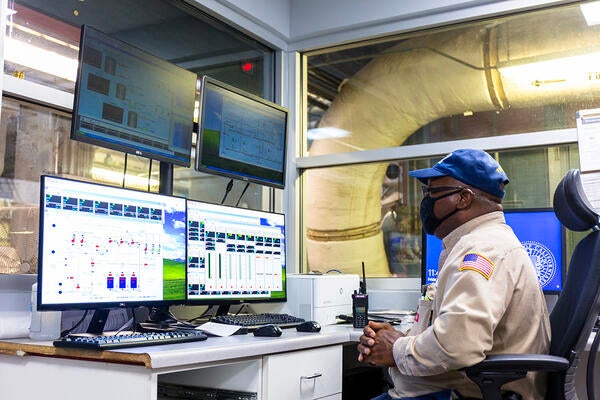 person in a control room monitoring screens