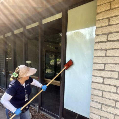 Custodian cleaning window