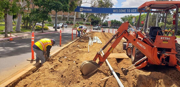 Landscapers digging trench for irrigation by hand and with equipment