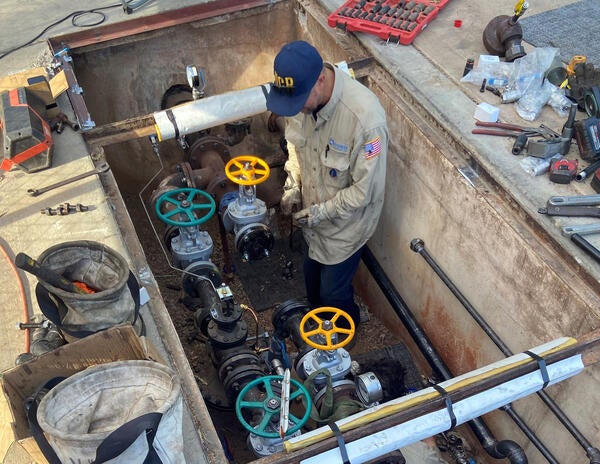 Building mechanical staff working in trench