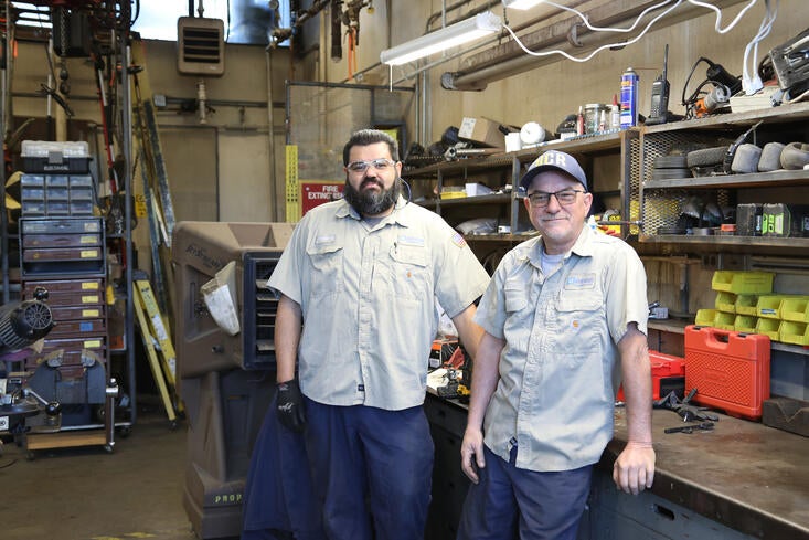 Two facilities workers in a repair shop